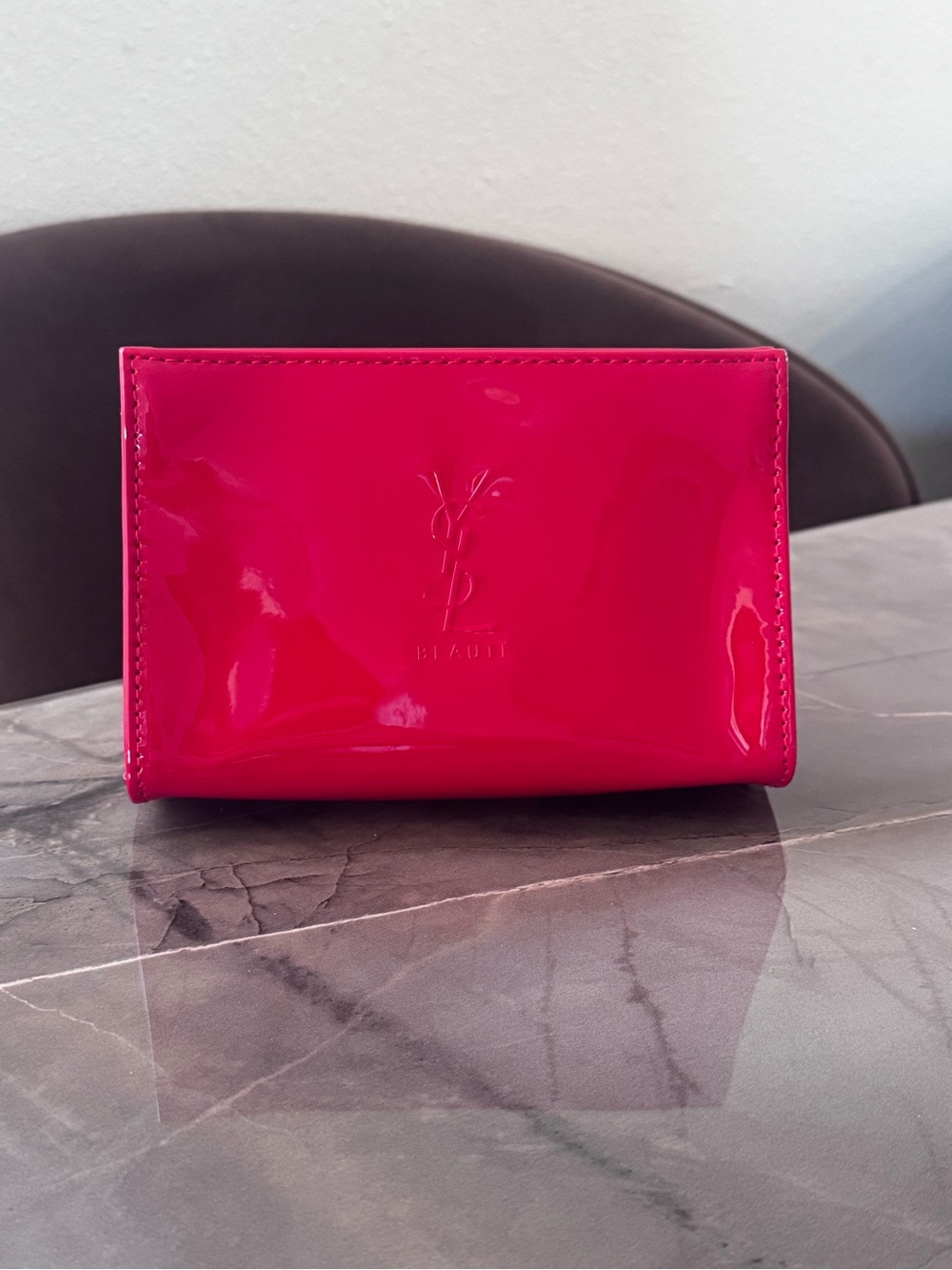 This is a bright red patent PVC Yves Saint Laurent Beauté cosmetic bag featuring